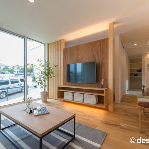 壁掛けテレビの上下に間接照明をいれた大きな掃き出し窓のリビング