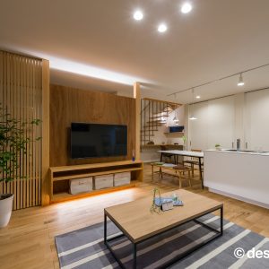壁掛けテレビの上下に設けた間接照明が映える夜のリビング