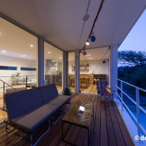 ２階リビングとフラットにつながる家具付きの夜のテラス