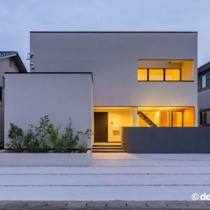 白い外壁の四角い住宅の夜間外観