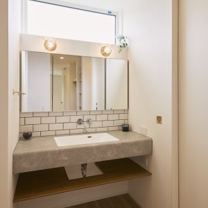 グレーを基調とした、白のタイルを用いた造作洗面台