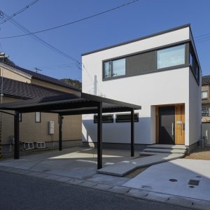玄関の木目が特徴のモノトーンの四角い家