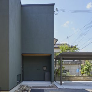 玄関軒天の木目がアクセントとなる塗り壁の家の外観