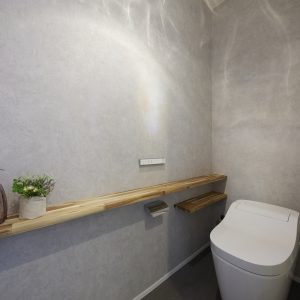 グレーを基調とした、照明の陰影が映えるトイレ空間