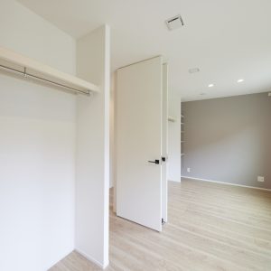 グレーのアクセントクロスとオープン収納のある子ども部屋